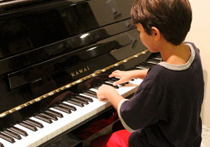 Kind beim Pianospielen.