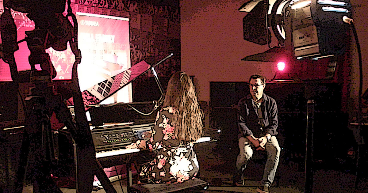 Kleine Dokumentation im Comic-Style zum Yamaha-Videodreh Digitalpiano Clavinova CVP-809 mit Susan Albers und Peter Baartmans im Musikhaus Kirstein in Schongau. Comic-Bild 23: Susan Albers am Piano, Peter Baartmans schaut ihr zu.
