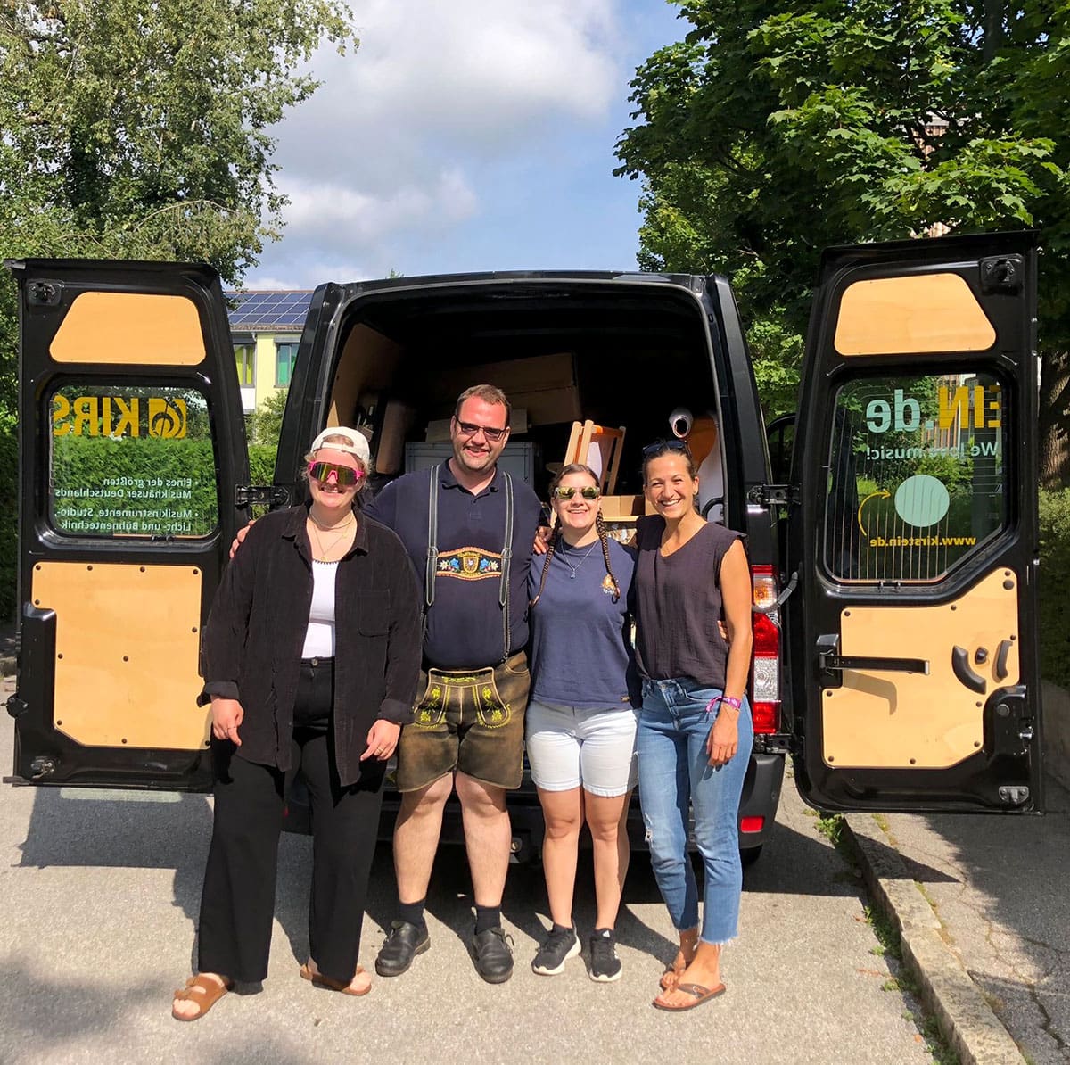 Das Brass-Wiesn-Team von Kirstein: Caro, Frank, Miri und Julia vor dem Transporter, der die Standausrüstung geladen hat.