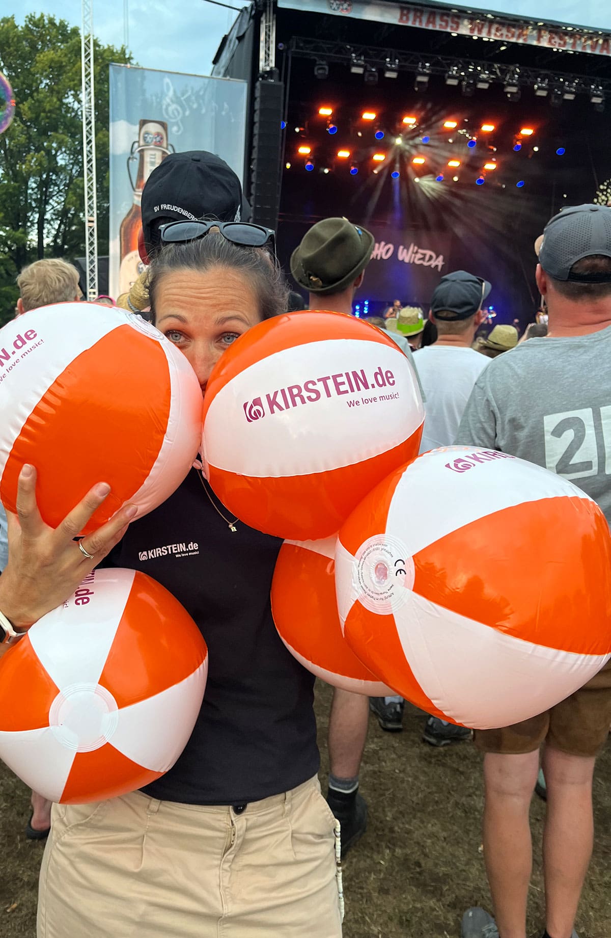 Kirstein-Kollegin Julia mit mehreren aufblasbaren Wasserbällen mit aufgedrucktem Kirstein-Logo.