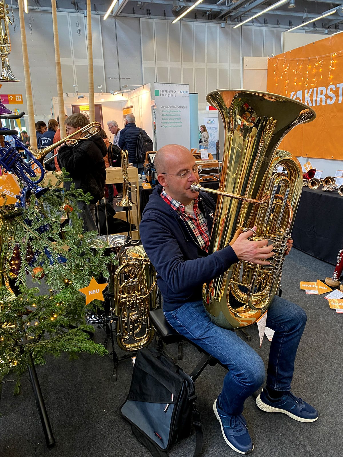 Besucher beim Messestand des Musikhaus Kirstein auf der BRAWO 2024 beim Spielen einer Lechgold-Tuba