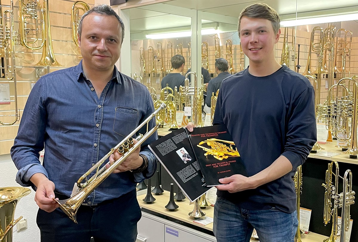 Vjeran Jezek zu Besuch im Musikhaus Kirstein. Zusammen mit einem Kollegen des Kirstein-Teams im Blechbläser-Raum.