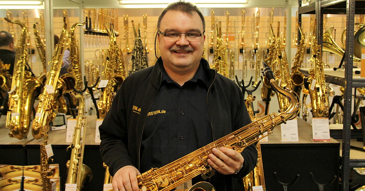 Markus Kübler mit einem Saxophon in der Bläserabteilung des Musikhaus Kirstein